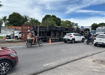 Carreta tomba, derruba poste e deixa motorista preso às ferragens em Manaus;