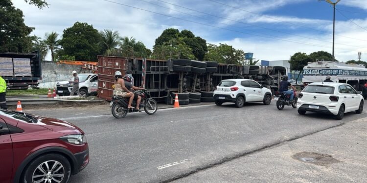 Carreta tomba, derruba poste e deixa motorista preso às ferragens em Manaus;