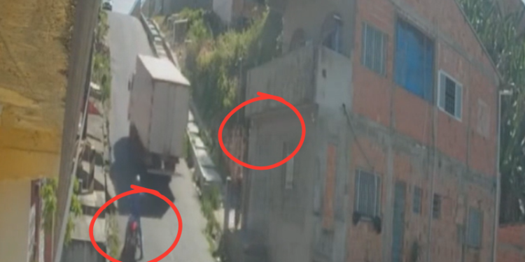 Caminhão que atingiu casa, quase esmaga pedestre e motociclista