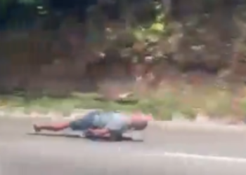 Homem desce deitado em skate entre carros e caminhões na Avenida do Turismo, em Manaus