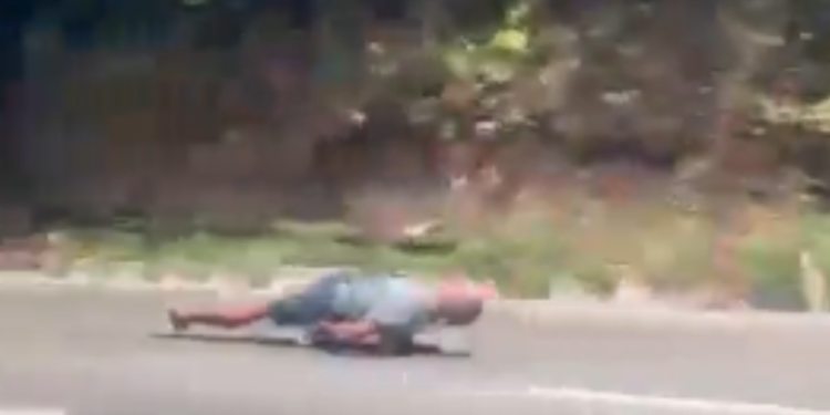 Homem desce deitado em skate entre carros e caminhões na Avenida do Turismo, em Manaus
